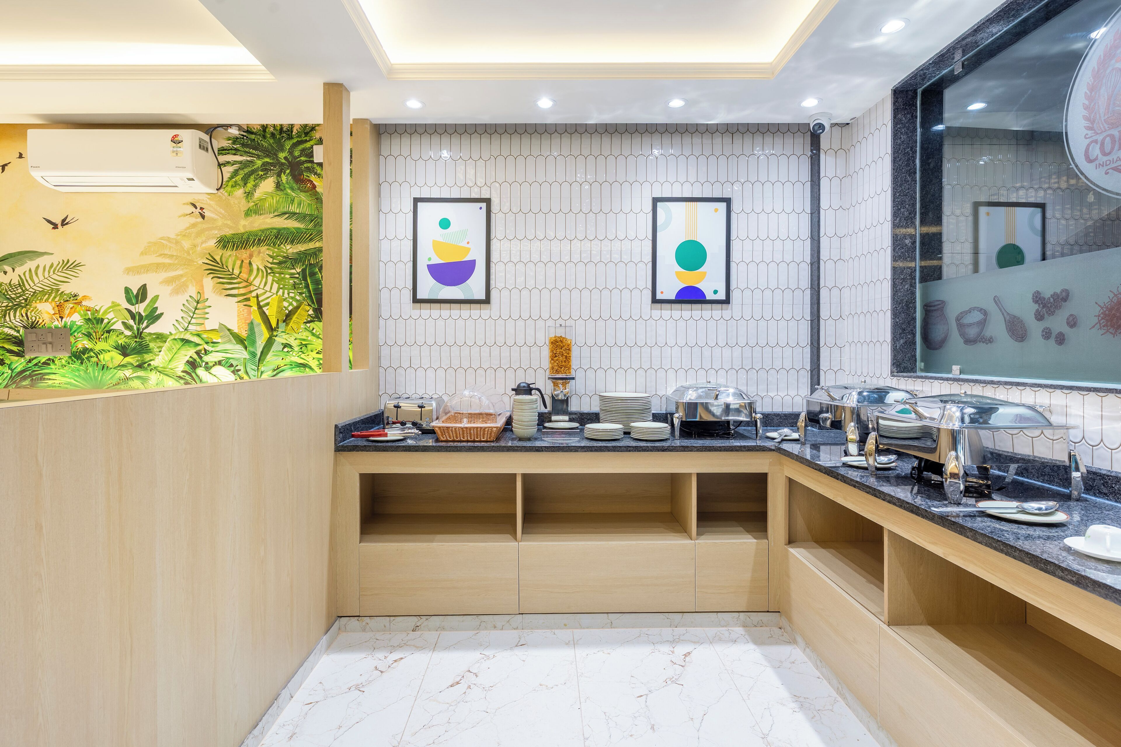 A kitchen with a marble countertop, wooden cabinets, and a wall mural.