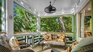A covered porch with wicker furniture, a ceiling fan, and a view of trees. - 'Lil' Gem'-restored 1960's bungalow (Mentone)
