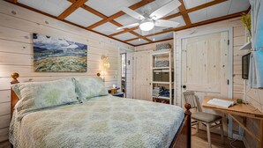 A bedroom with a bed, a desk, a chair, a ceiling fan, a painting, and a wardrobe. - 'Lil' Gem'-restored 1960's bungalow (Mentone)