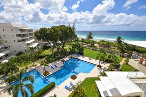Ein Hotel mit Swimmingpool, Palmen und Blick auf den Ozean.