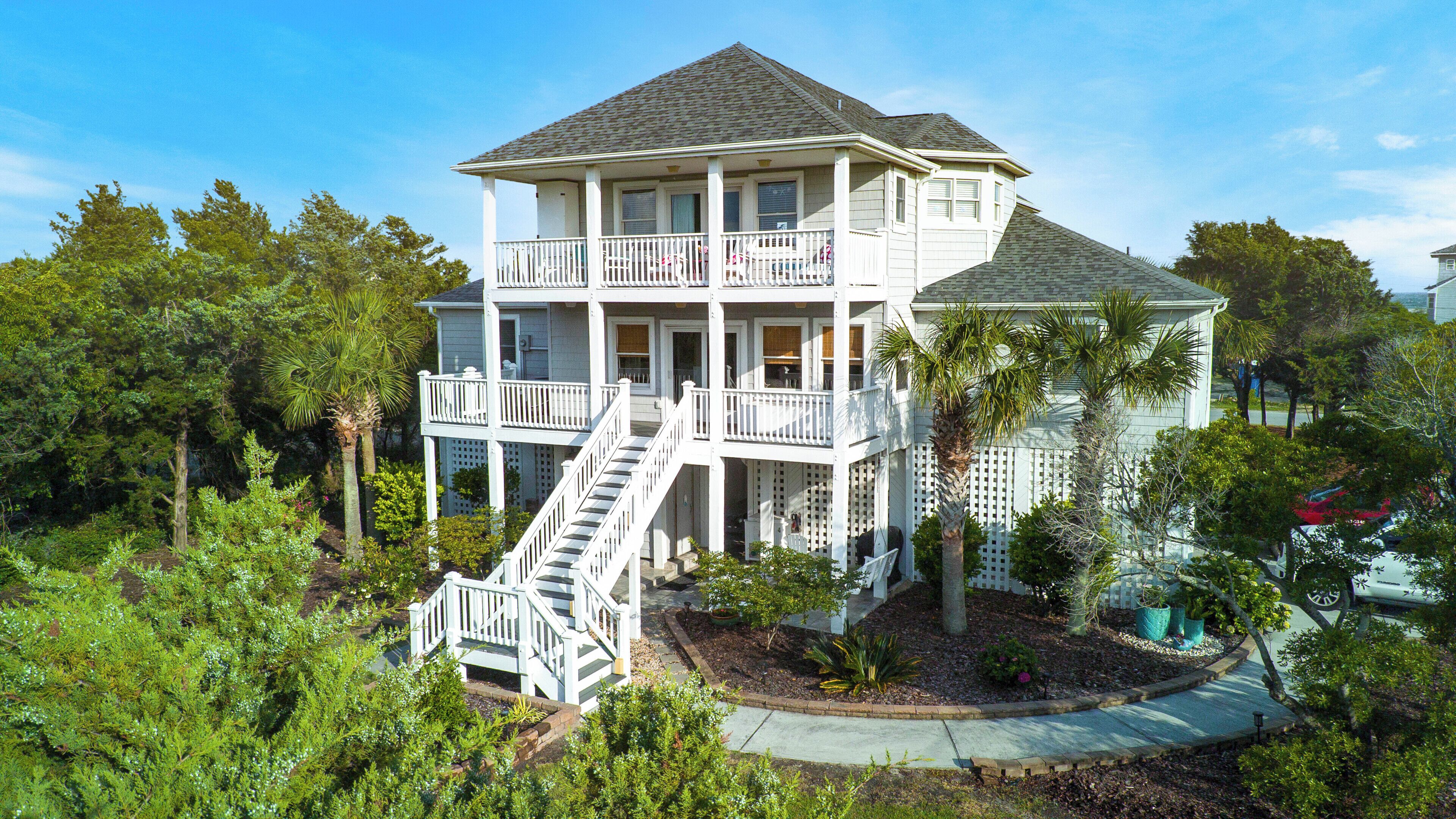 A two-story house with a balcony, a staircase, and a garden.
