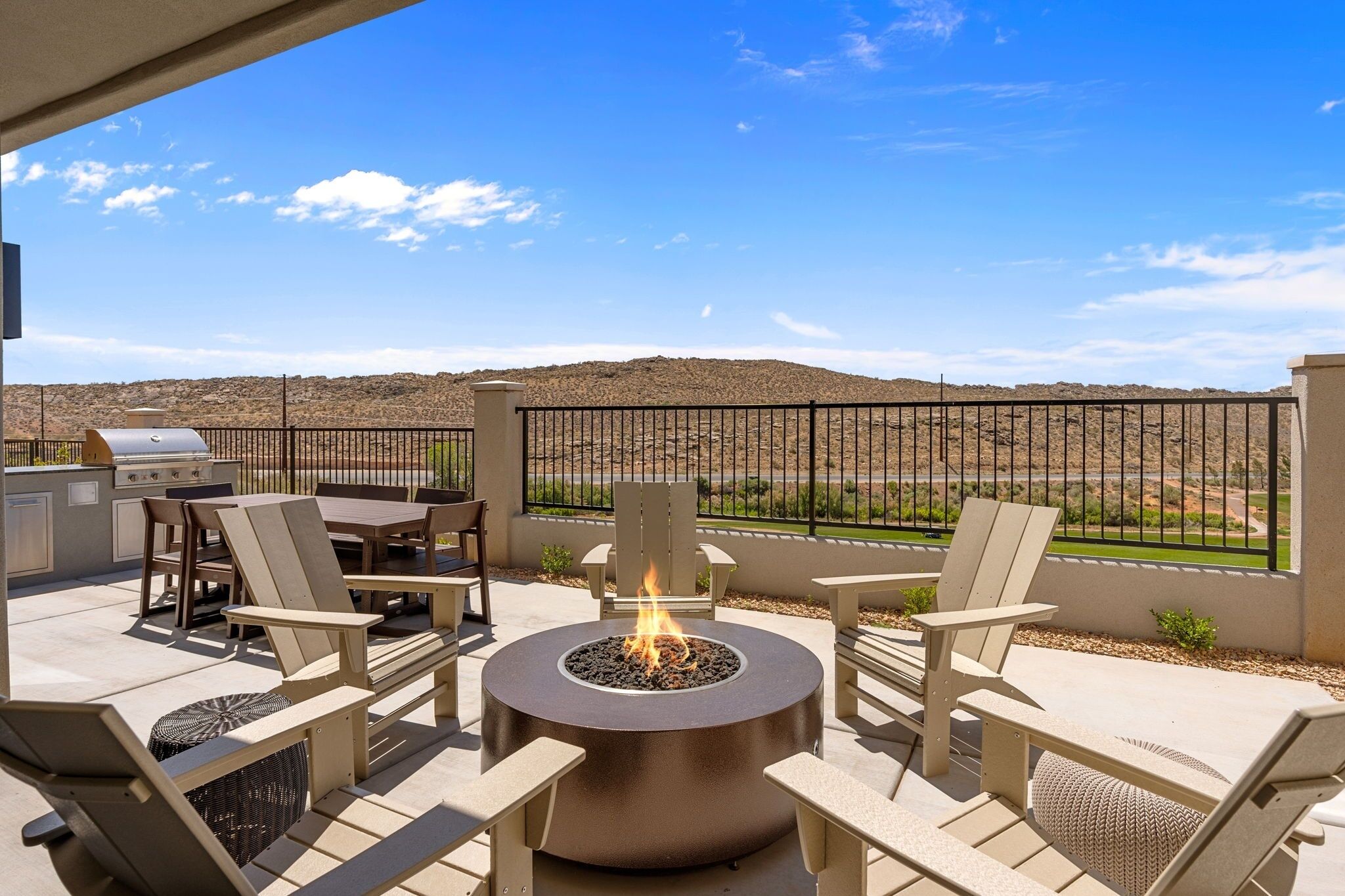An outdoor patio with a fire pit, seating, and a grill.