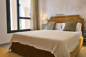 A bed with a headboard, a bedside lamp, and a window with curtains. - ALLONBAY beach front residence (Villajoyosa)