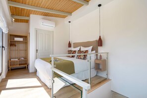 A bedroom with a bed, bedside table, hanging light, wardrobe, and an air conditioning unit. - Exclusive Duplex With Private Terrace Pool in Seville Feria 21 (Seville)