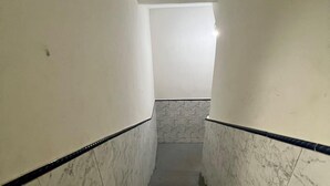 A narrow stairway with marble walls and black handrails, leading to a landing with a light fixture. - Studio apartment in Prainha de Muquiçaba, 5 minutes from Praia do Morro, excellent for couples. (Guarapari)