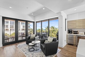 Eine moderne Wohnung mit Balkon, einer Küche und einer Sitzecke mit Blick.