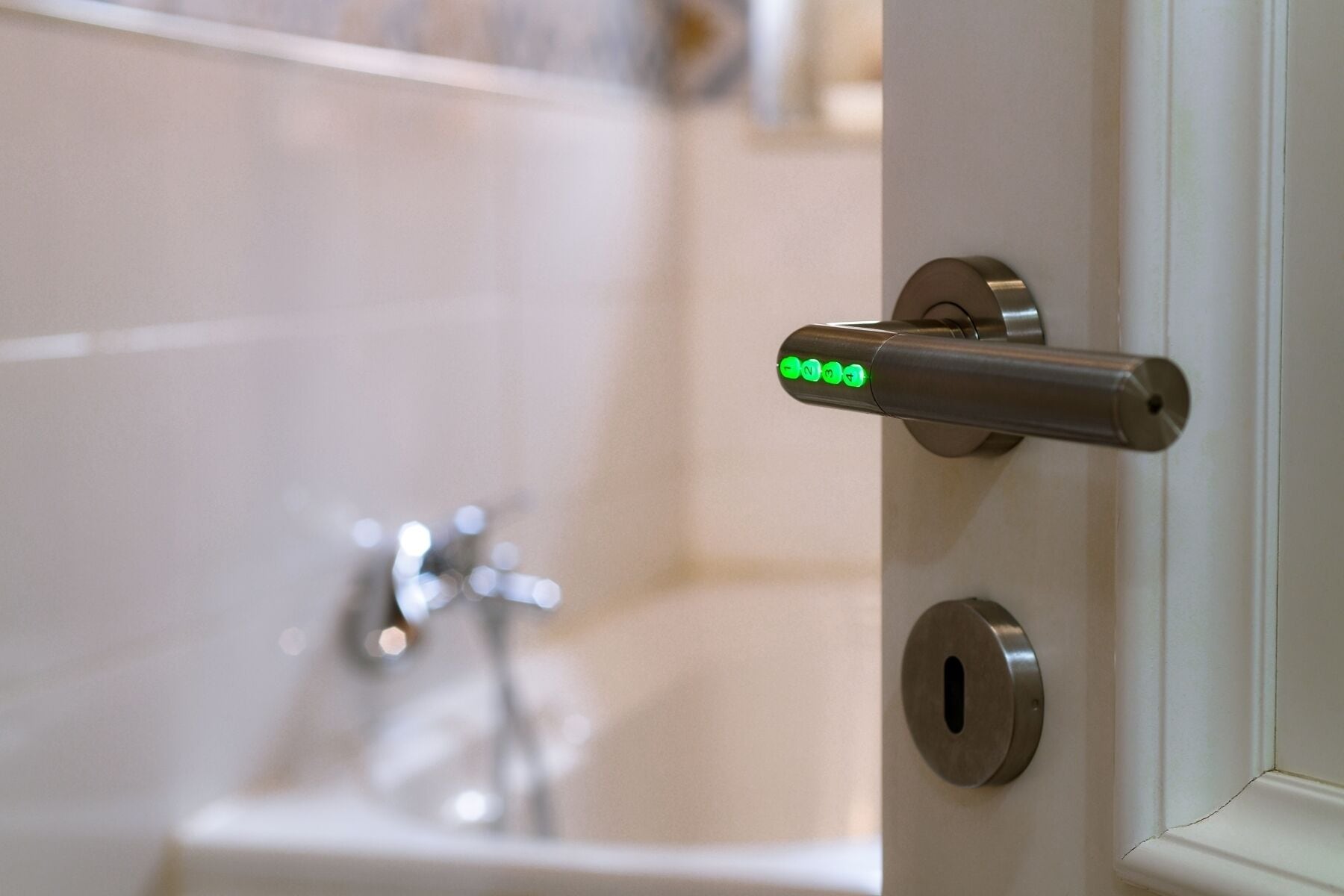 Une porte de salle de bain avec une poignée métallique et un trou de serrure.