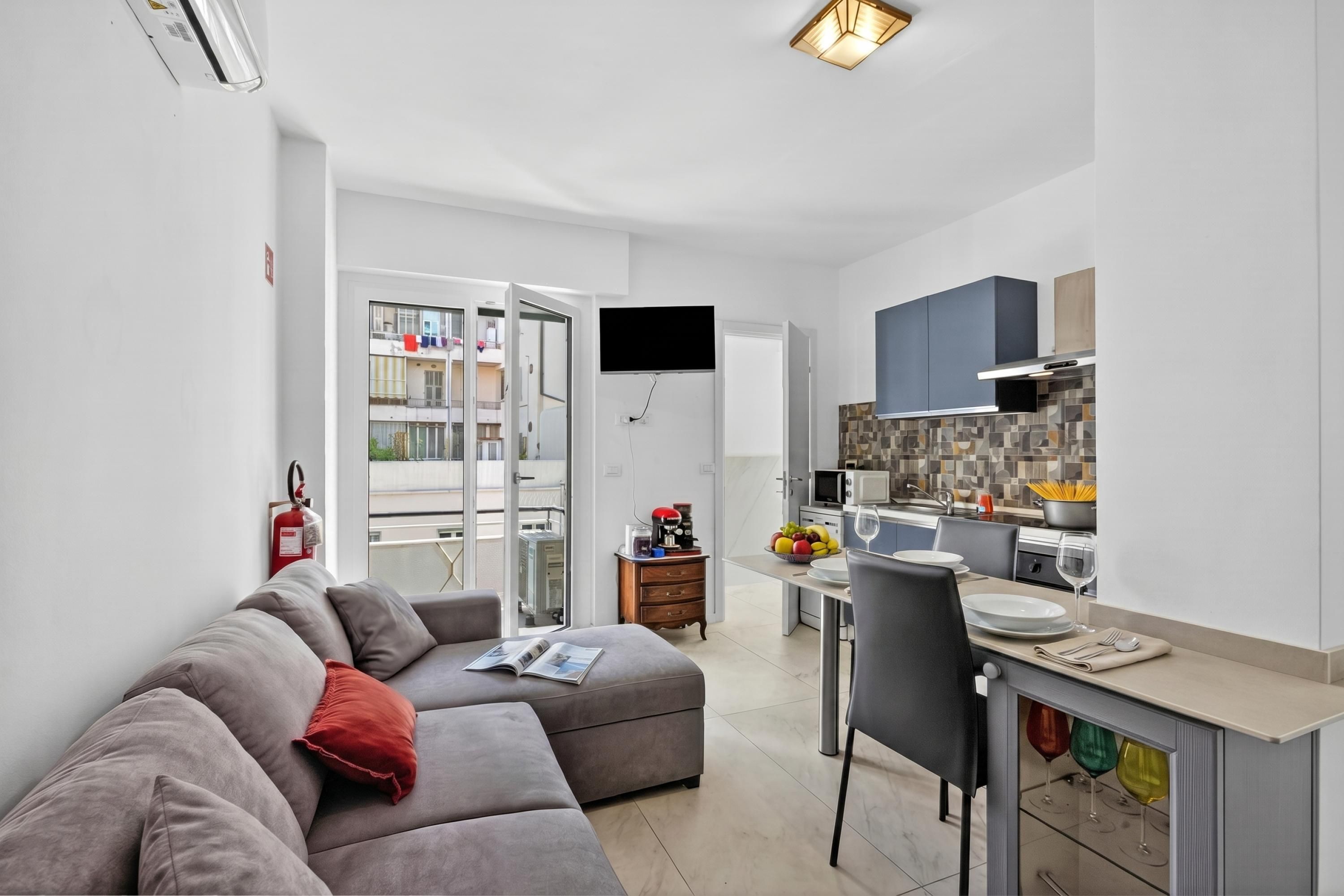 Un apartamento moderno con sala de estar, kitchenette y balcón.