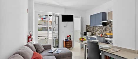 Un apartamento moderno con sala de estar, kitchenette y balcón.