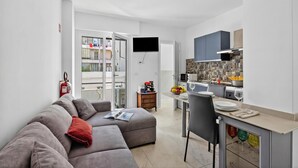 Ein modernes Apartment mit Wohnzimmer, Küchenzeile und Balkon.