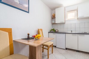 A compact kitchen with a dining table, chairs, a sink, and a dishwasher. - Istrian Villa Stella for 8: Pool & Sauna (Labin)