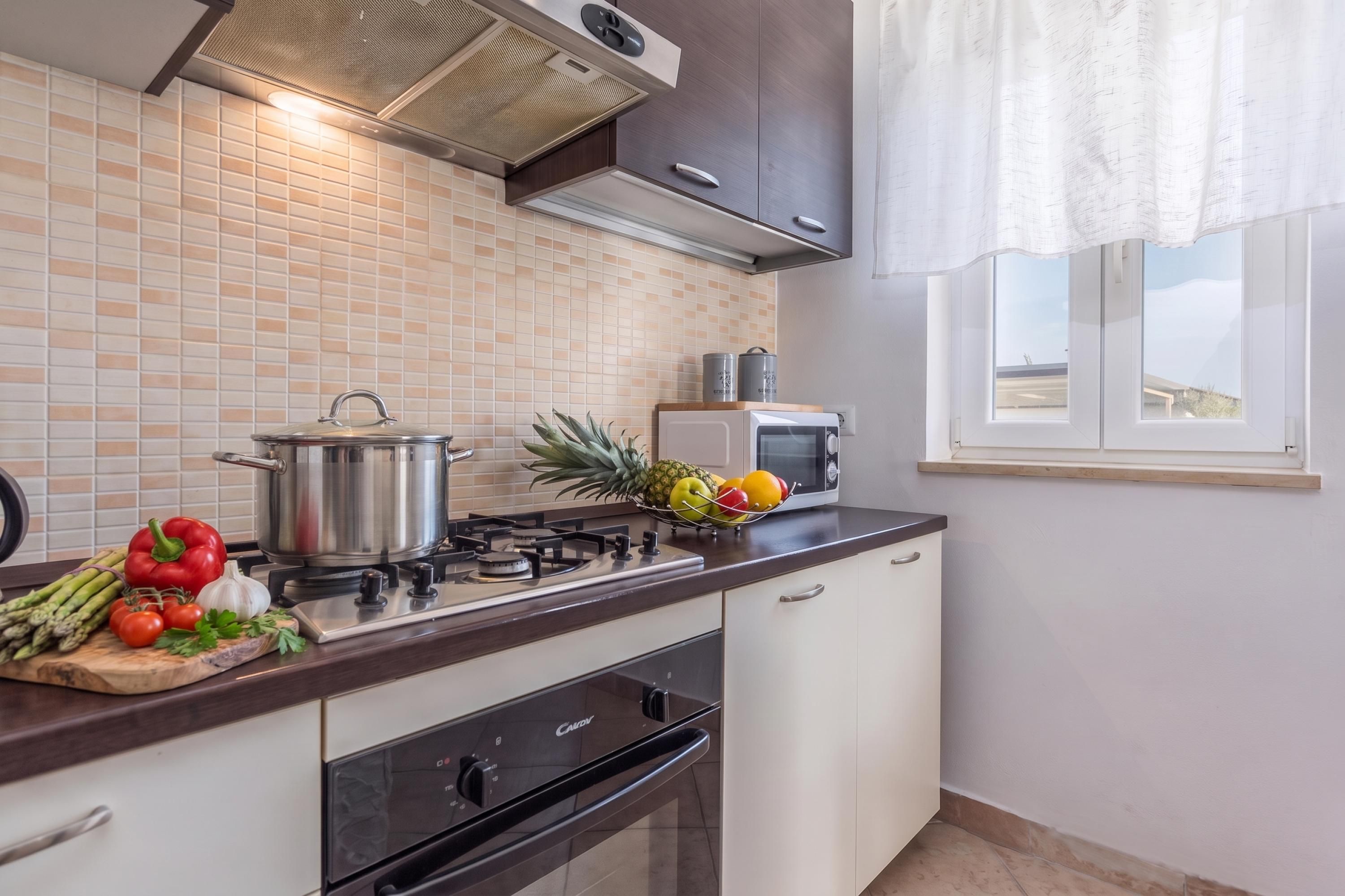 Una cocina moderna con estufa a gas, horno y microondas.