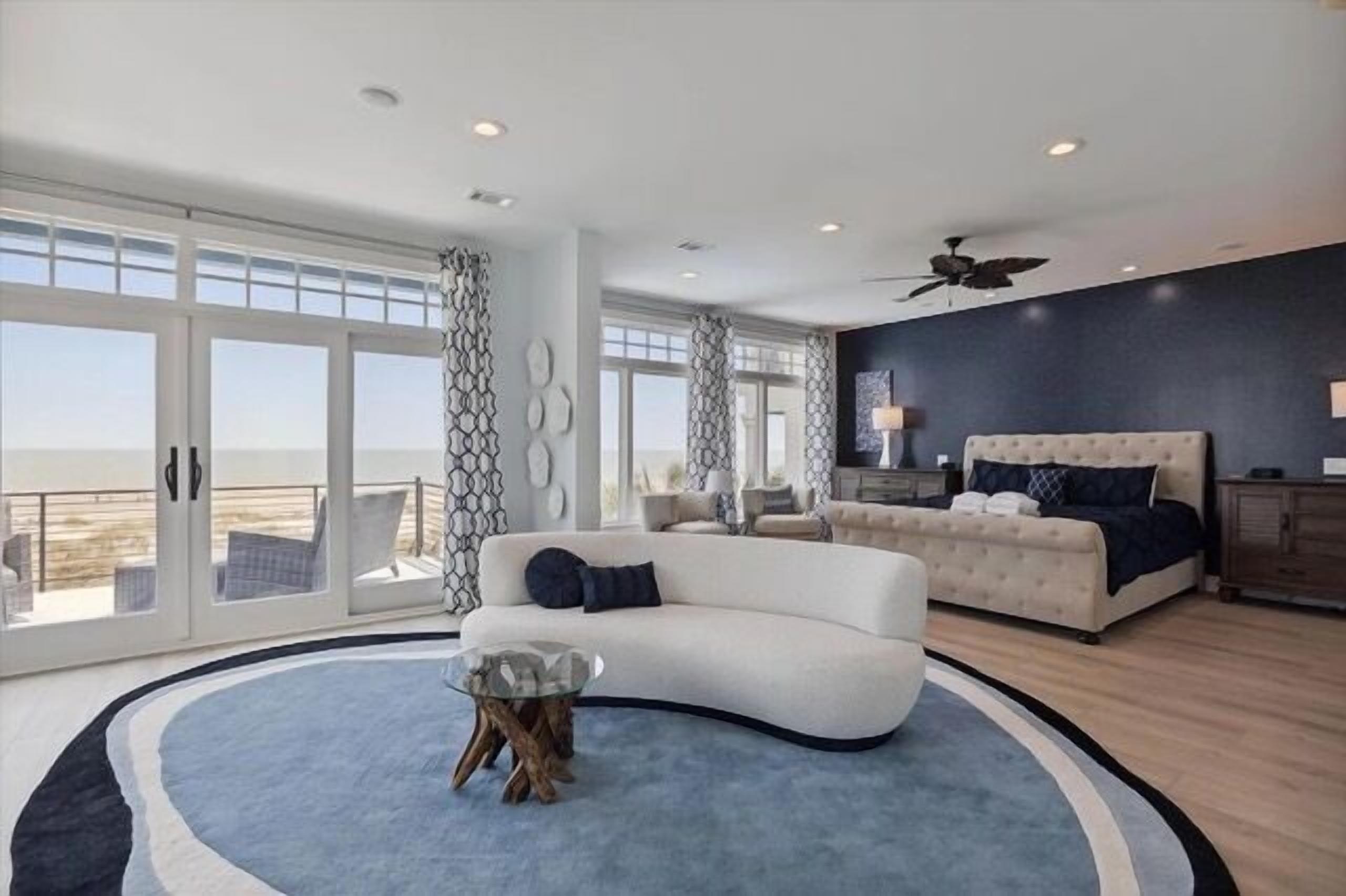 A modern bedroom with a large bed, a sofa, and a glass coffee table.