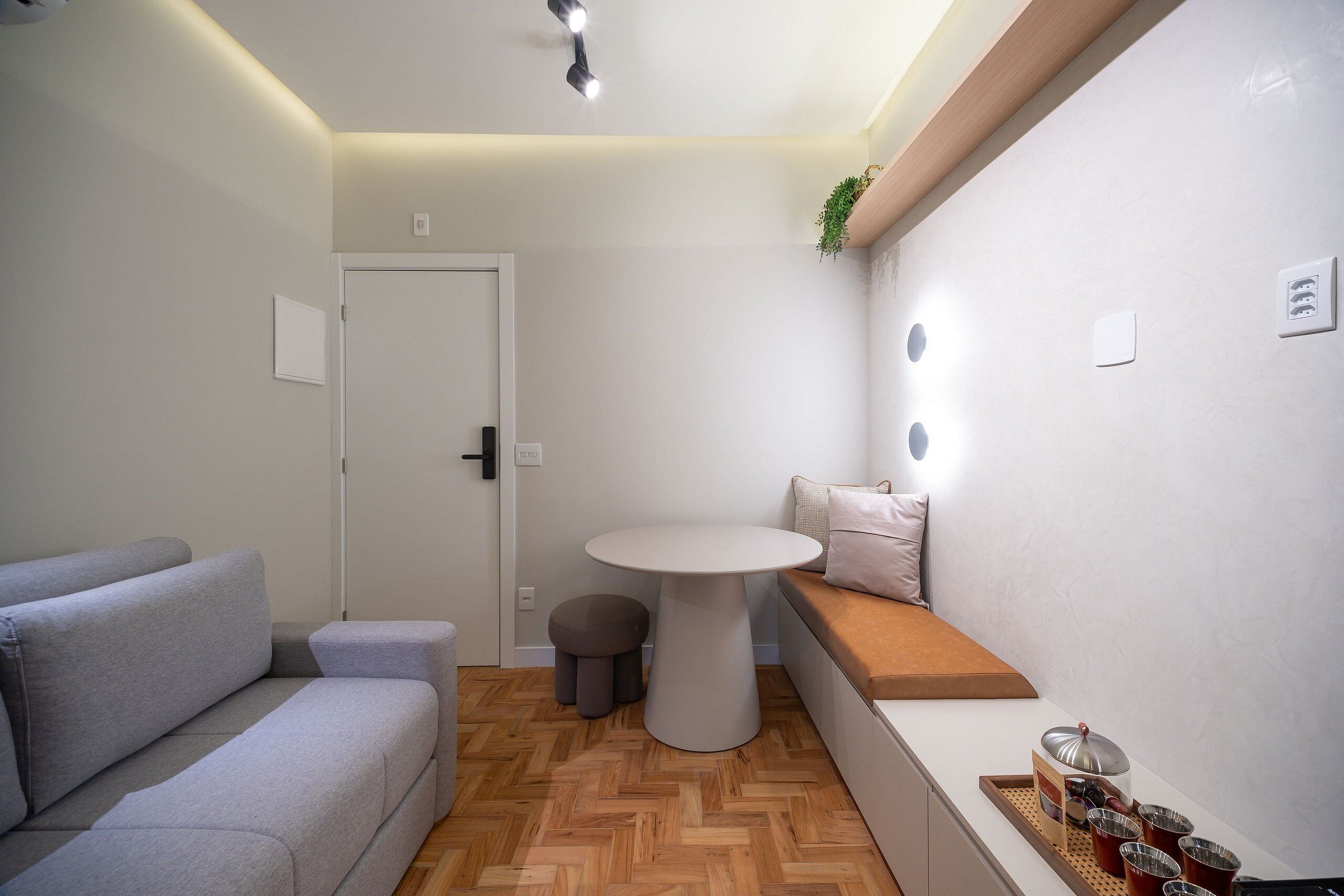 Ein modernes Wohnzimmer mit einer Couch, einem runden Tisch und einer Bank.