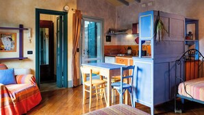 Een kleine keuken met een eethoek, een bed en een slaapbank.