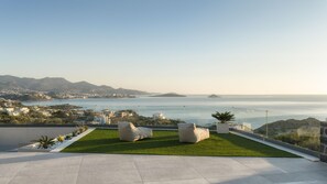 A rooftop terrace with a view of the sea, a grassy area, and modern outdoor furniture. - 4 Bedroom Luxury Villa (Agios Nikolaos)