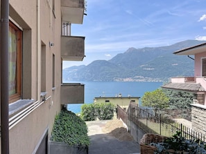 Ein Wohngebäude mit einem Balkon mit Blick auf einen Bergsee.