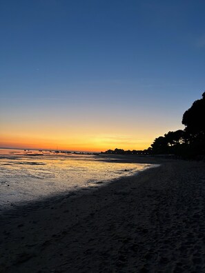 Una playa con cielo despejado y agua tranquila.