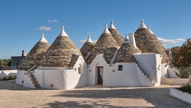 Un bâtiment doté de plusieurs toits coniques et d’une entrée centrale.
