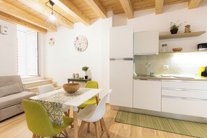 Eine moderne Küche mit weißen Schränken, einer Holz Arbeitsplatte und einem eingebauten Backofen.
