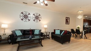 A modern living room with two sofas, a coffee table, and decorative wall art. - Modern Charleston Getaway (North Charleston)