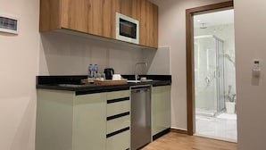 Una cocina moderna con microondas, lavavajillas y dispensador de agua.