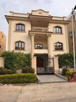A two-story building with a symmetrical facade, large windows, and a central balcony.