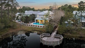 A house with a swimming pool, a dock, and a forested area. - NEW Designer WaterColor Home with Private Pool, Deluxe Outdoor Spaces, and LSV (Santa Rosa Beach)