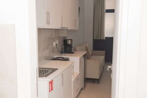 A compact kitchenette with a coffee maker, a microwave, and a sink. - Limani Blue, Escape Gytheio Hideaway by the Sea (Gytheio)