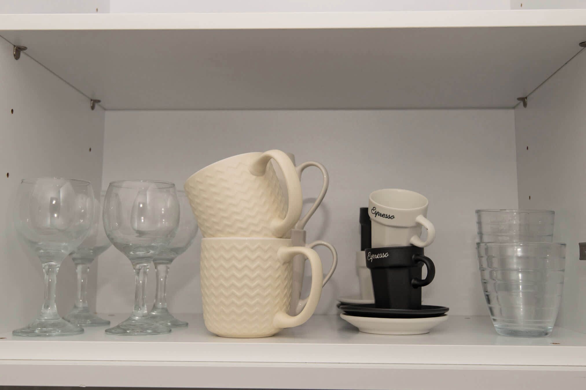 A shelf with various glassware and a coffee maker.