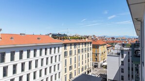 Un immeuble de grande hauteur, doté de nombreux étages, de grandes fenêtres et d’un toit recouvert de tuiles rouges.