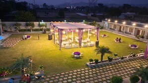 An outdoor event space with a covered seating area, a pool, and a landscaped garden. - THE FORESTAA RESORT (Haridwar)