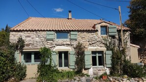 A stone house with a tiled roof, green shutters, and a chimney. - Holiday Home 'Bergerie L'Occitane' with Private Pool, Terrace and Wi-Fi (La Caunette)