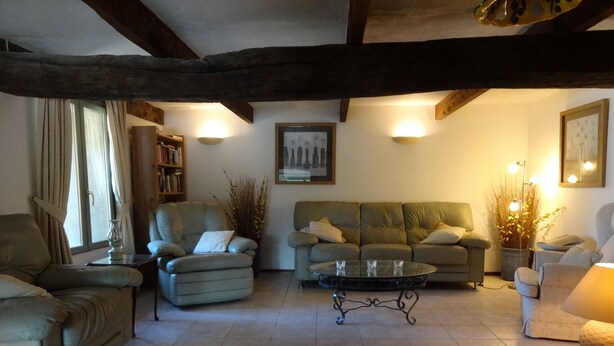 A cozy living room with a sofa, armchairs, a coffee table, and a bookshelf. - Holiday Home 'Bergerie L'Occitane' with Private Pool, Terrace and Wi-Fi (La Caunette)