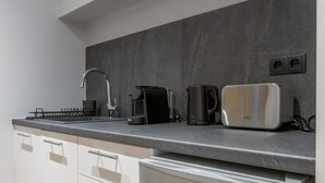 Eine moderne Küche mit einem Edelstahlkühlschrank, einer Kaffeemaschine und einem Toaster auf der Arbeitsfläche.