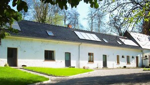 A white building with a tiled roof, multiple windows, and a gravel driveway. - Gîte La Toupiole: Private Terrace, Private Garden & Wi-Fi in Hucqueliers (Hucqueliers)
