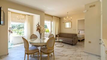 A dining area with a round table, chairs, and a vase of flowers.