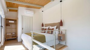 A modern bedroom with a bed, bedside tables, a wardrobe, and an air conditioning unit. - Genteel Home Feria Terrace 21 (Seville)