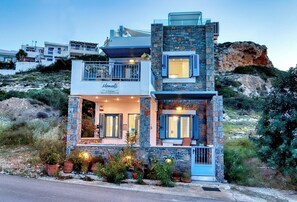 A multi-story building with a stone facade, balconies, and a restaurant named 'Moments.' - Seafront Villa Moments, by Estia (Mochlos)