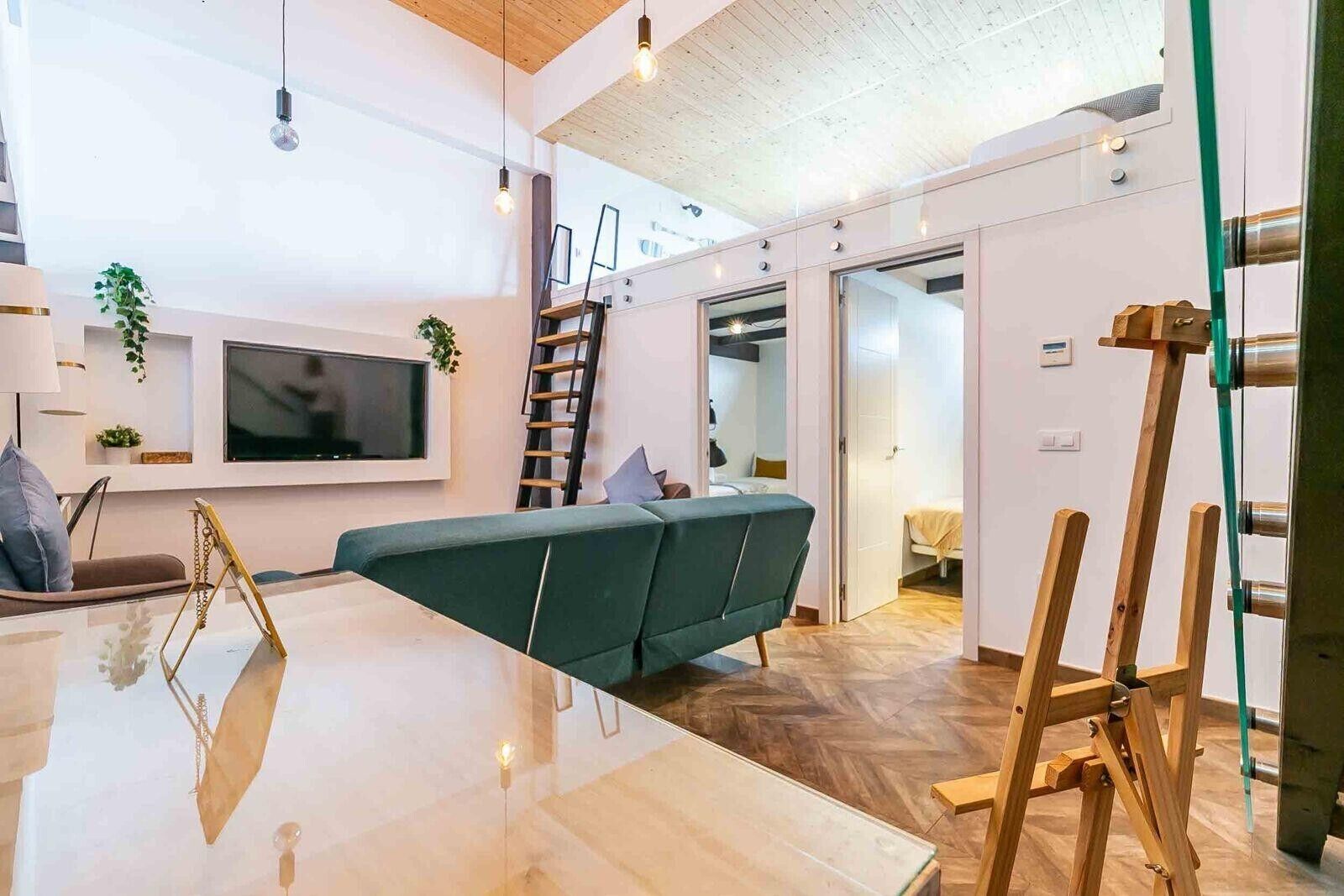 Een moderne woonkamer met een bank, een televisie en een houten ladder.