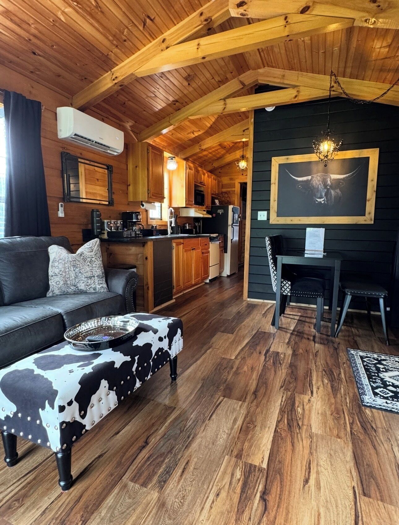 A cozy cabin interior with a living area, kitchenette, and dining space.