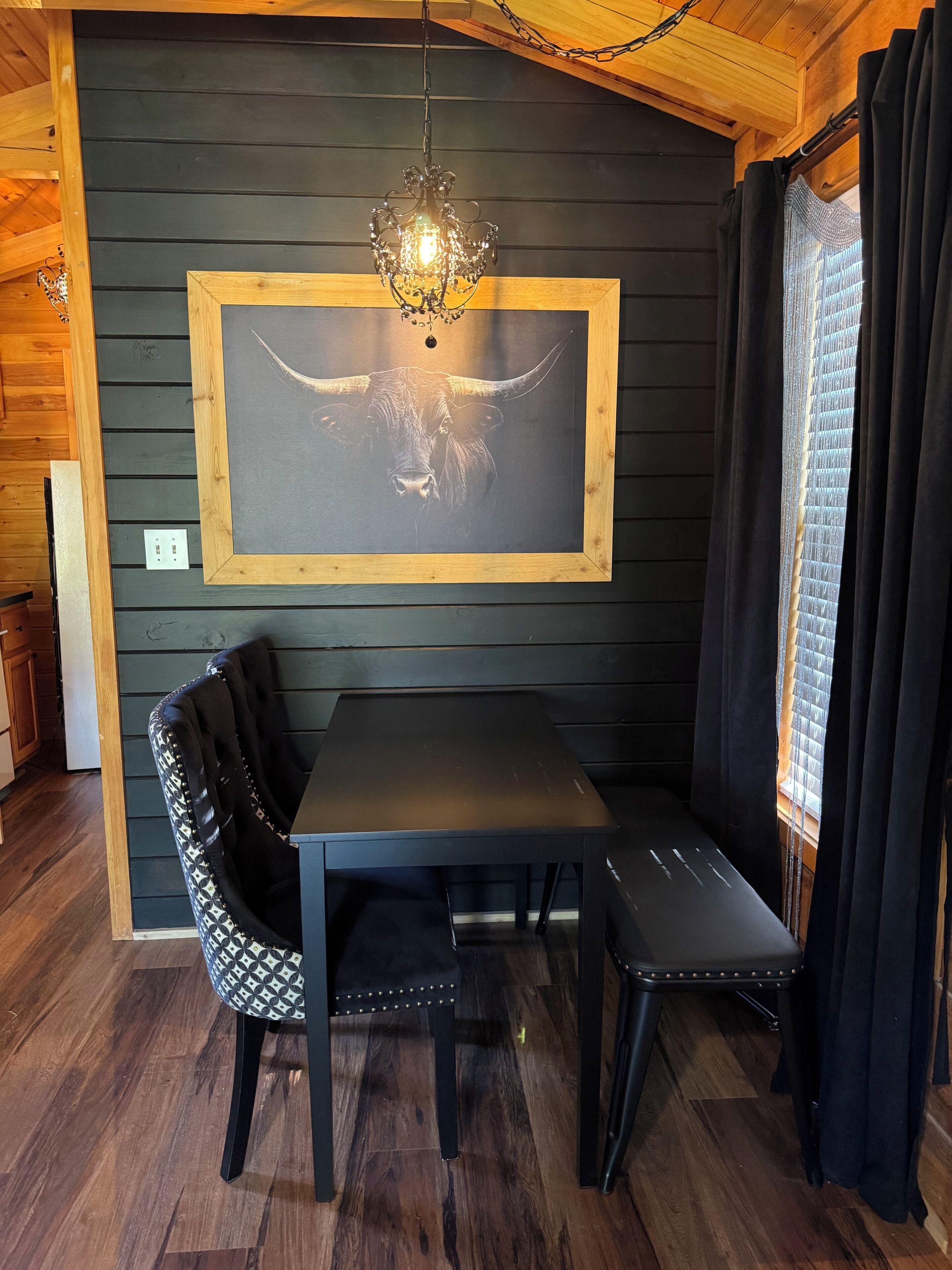 A dining area with a table, chairs, and a chandelier.
