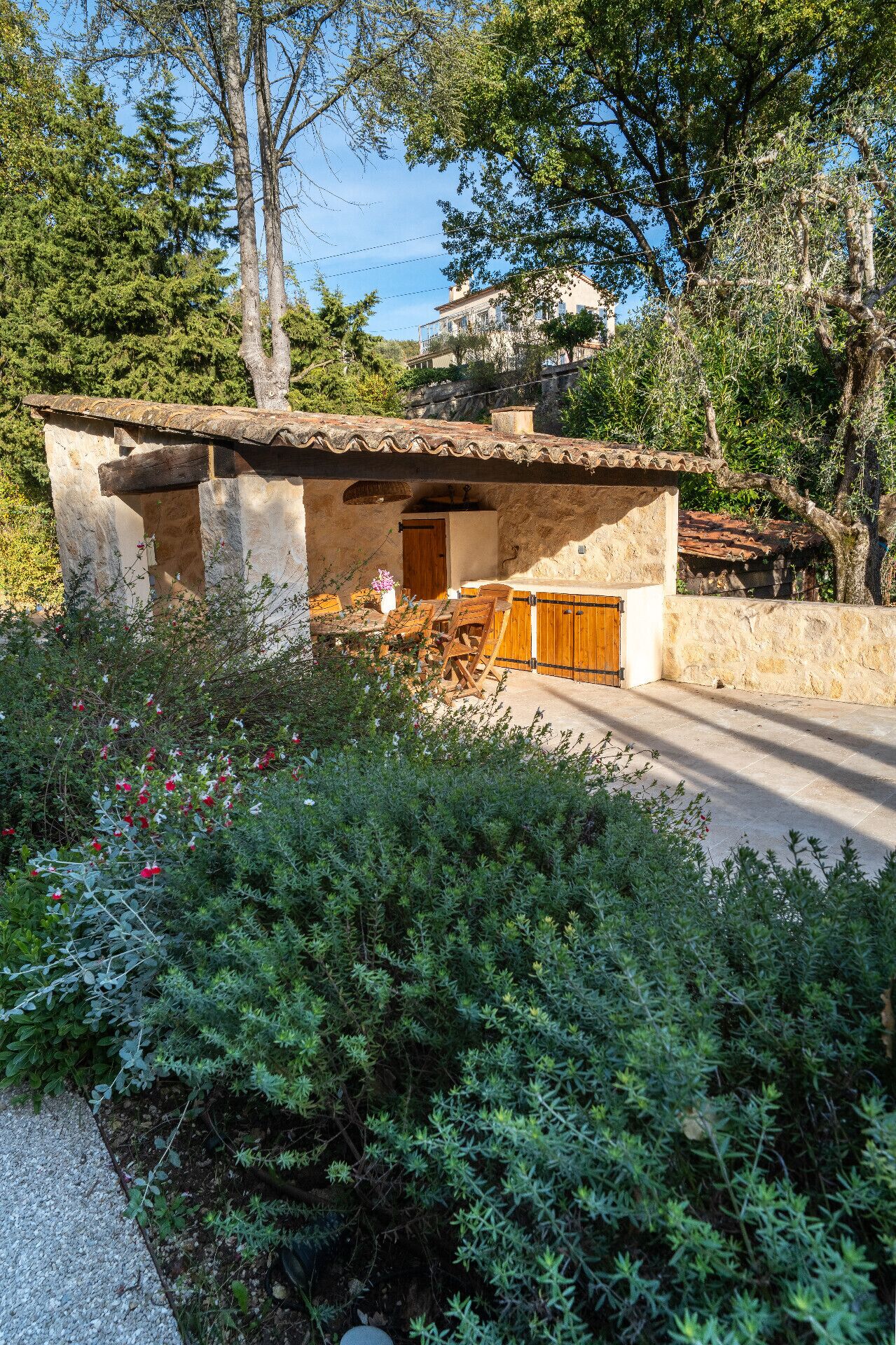 A rustic stone building with a tiled roof, a wooden door, and a small porch area.