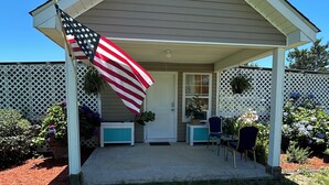 A house with a covered porch, a flag, and a door.