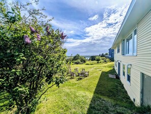 Una casa con un césped cuidado, mobiliario exterior y vistas al cielo.