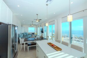 A modern kitchen with a large island, dining area, and a view of the ocean. - BREATHTAKING OCEAN FRONT VIEW! PRIVATE POOL AND PROTECTED DOCK (Marathon)