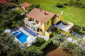Ein zweistöckiges Haus mit Pool, Sitzgelegenheit im Freien und Garten.