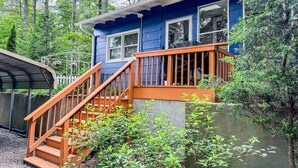 Ein blaues Haus mit einer Holztreppe, die zu einer Terrasse führt.