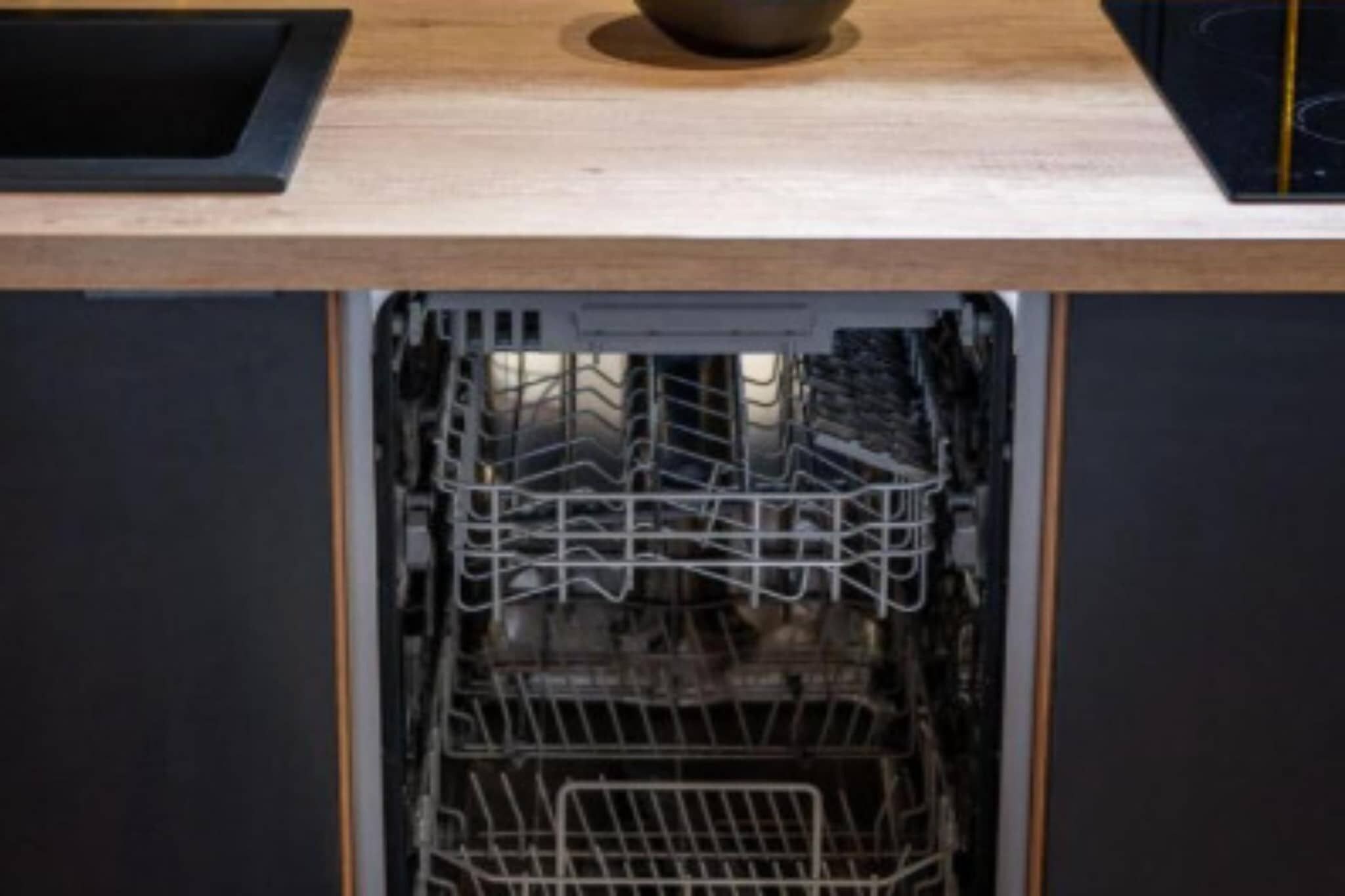 Un lave-vaisselle ouvert, avec des étagères à l’intérieur.