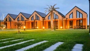 A modern building with a symmetrical facade, large windows, and a well-lit entrance. - Premium Holiday home with a pool, sauna, jacuzzi in Kopan (Kopan)
